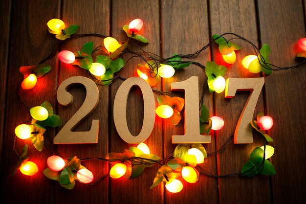 Free Photo 2017 happy new year, wooden figures and flashing lights on the retro desktop