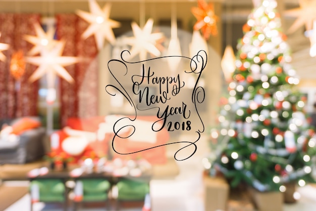 Free photo 2018 happy new year text on colorful bokeh blur background from decorated christmas tree.