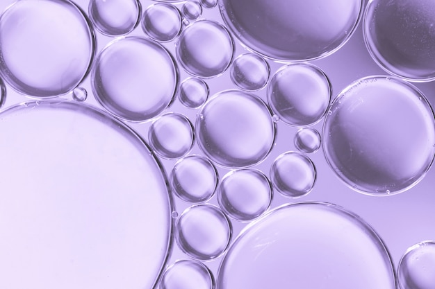 Abstract air bubbles in liquid on lilac colored background