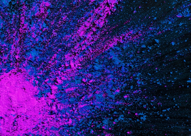 Free photo abstract blue and pink dry holi colors splatted on black background