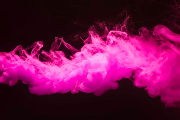 Abstract dense fluffy puffs of pink smoke on black background