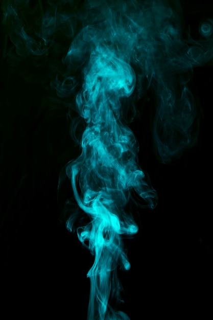 Abstract green smoke flowing upward over the black background