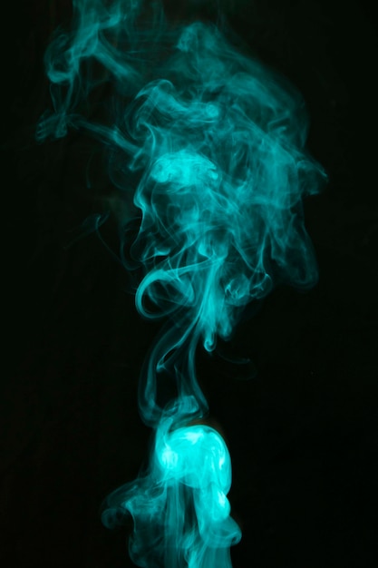 Abstract green smoke spread over the black background