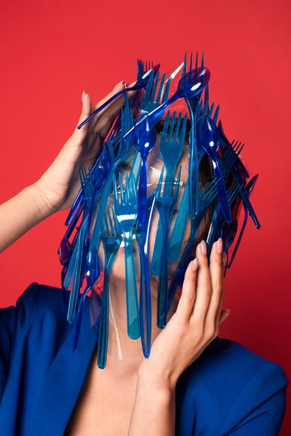 Abstract representation of blue plastic tableware waste on woman