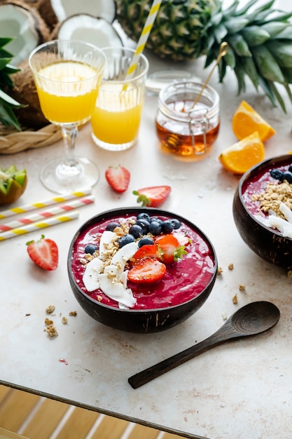 Free Photo acai smoothie in coconut shell with orange juice