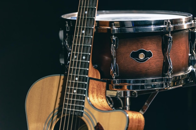 Free photo acoustic guitar and snare drum on a black background isolated