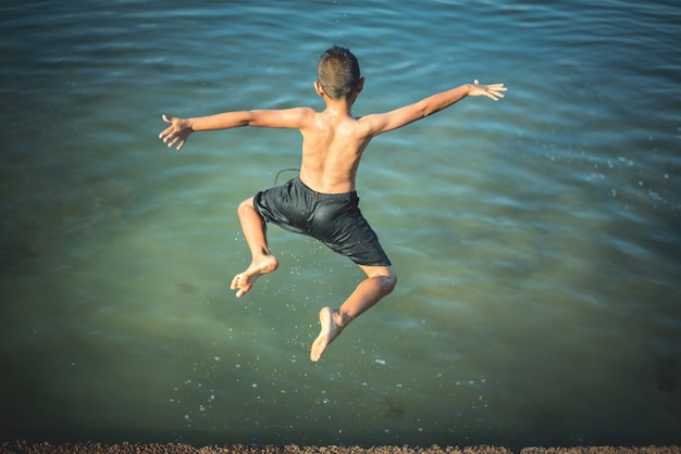 Free photo active boy jumping into the water