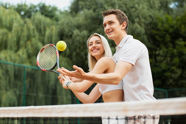 Active couple playing tennis together