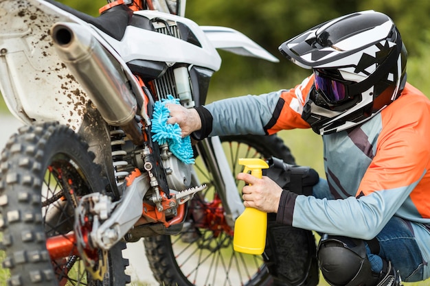 Active man cleaning motorbike outdoors