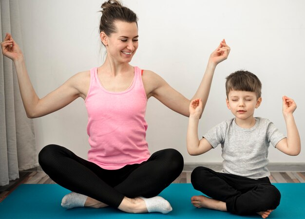 Active mother practicing yoga with her son