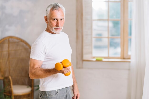 Active senior man exercising with dumbbells