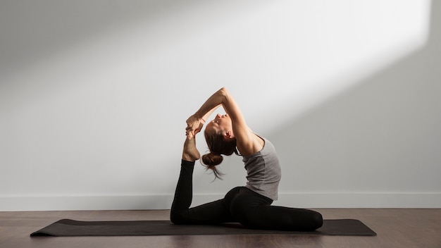 Active woman practicing yoga at home