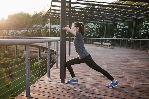 Active woman stretching at sunset