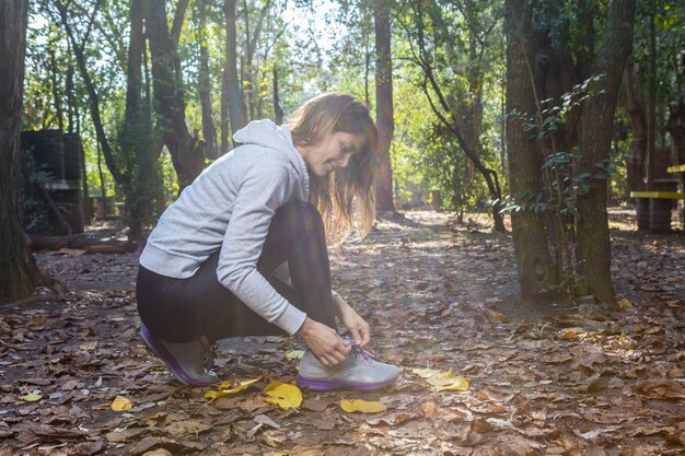 Free photo active woman tying shoelaces on sneakers