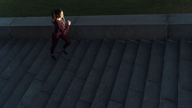 Active young woman climbing stairs