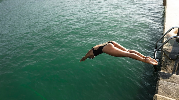 Free photo active young woman jumping in the water