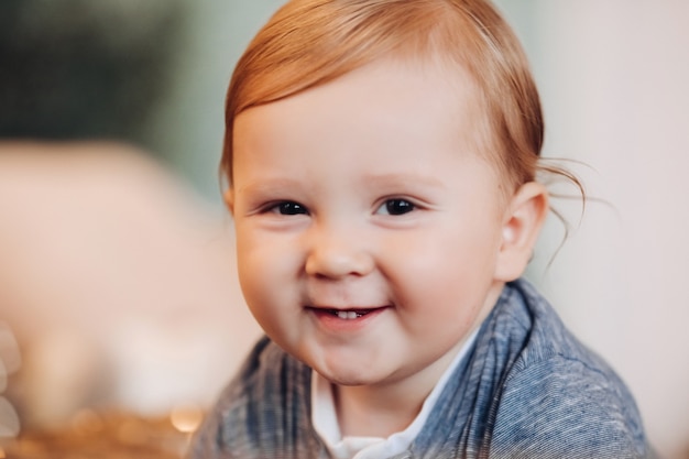 Adorable baby boy smiling at camera. blurred background.