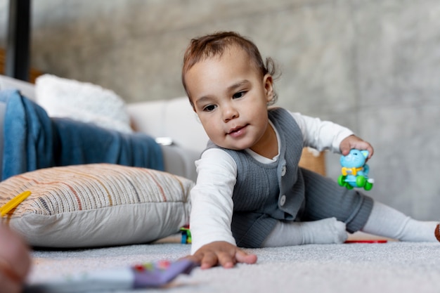 Adorable baby crawling and playing on the floor with toy