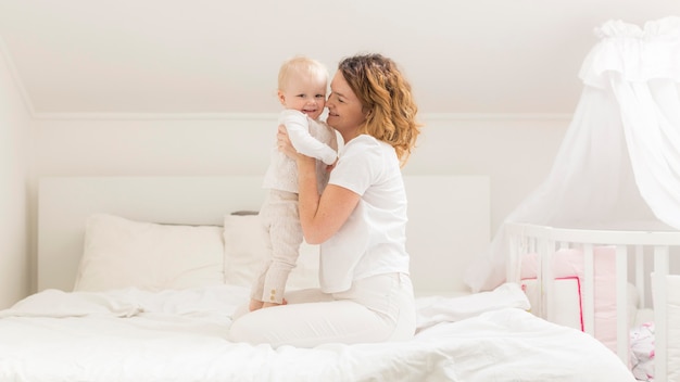 Adorable baby girl together with mother at home