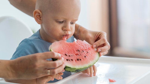 Adorable baby playing with food