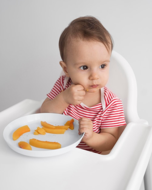 Adorable baby playing with food