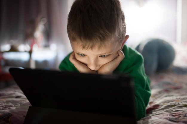 Free photo adorable boy watching film on tablet