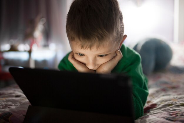 Adorable boy watching film on tablet