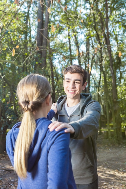 Free photo adorable boyfriend doing warm-ups with his girlfriend in the forest