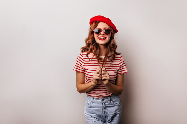 Adorable caucasian girl with ginger hair fooling around . Photo of pleased french lady wears cool sunglasses.