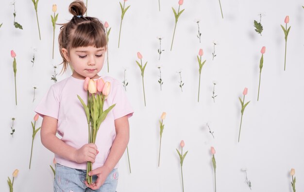 Adorable child looking at tulips