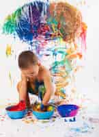 Free photo adorable child playing with paints