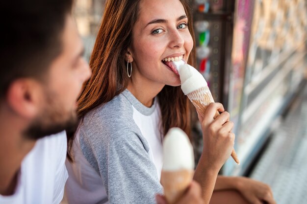 Adorable couple eating ice creams at fair