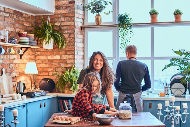 Adorable family together cooking breakfast in loft style kitchen.