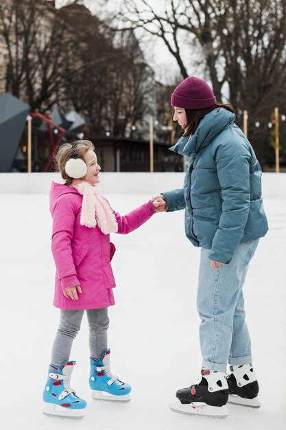 Adorable girl and mother holding hands