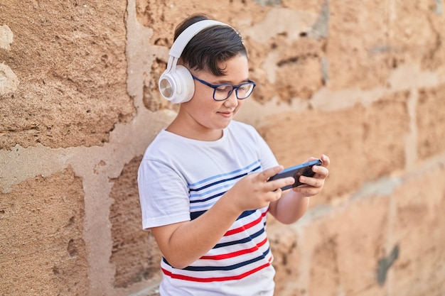 Free Photo adorable hispanic boy smiling confident playing video game at street