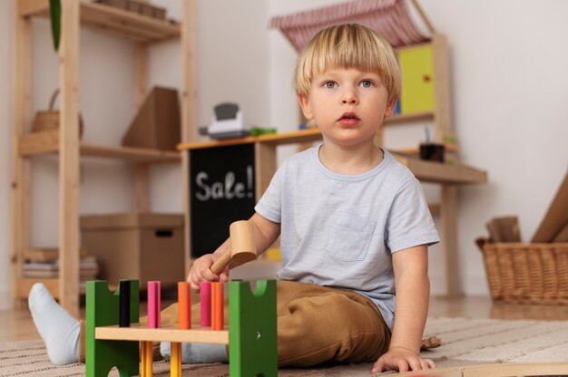 Adorable kid playing with toy full shot