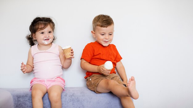 Adorable kids sitting and enjoying their ice creams