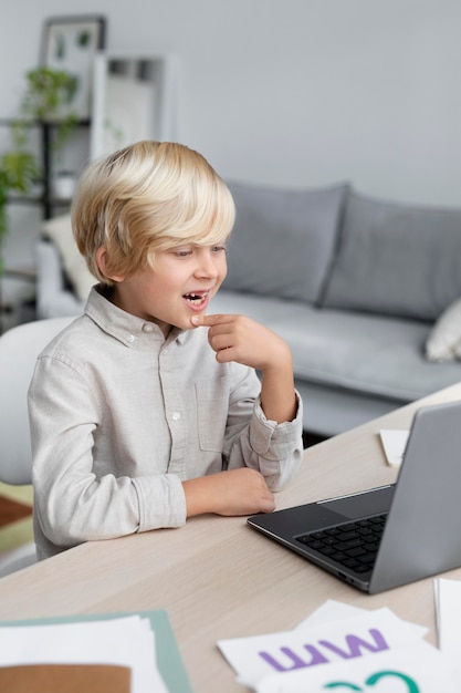 Adorable little boy doing an online session of speech therapy