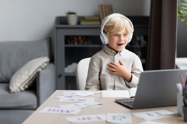 Adorable little boy doing an online session of speech therapy