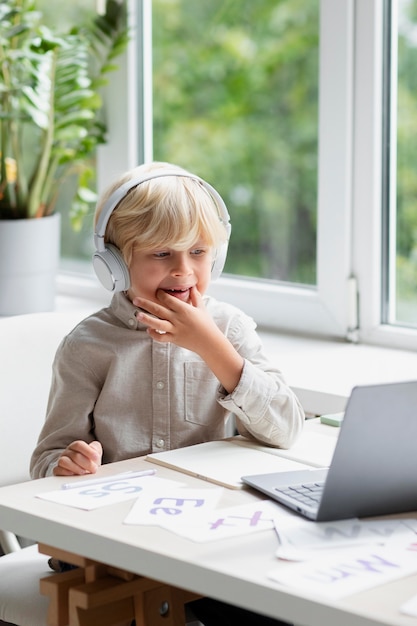 Adorable little boy doing an online session of speech therapy