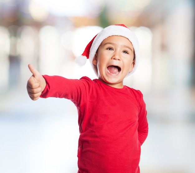 Adorable little boy showing a positive sign