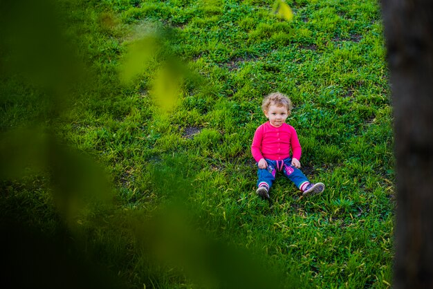 Adorable little boy sitting on the lawn