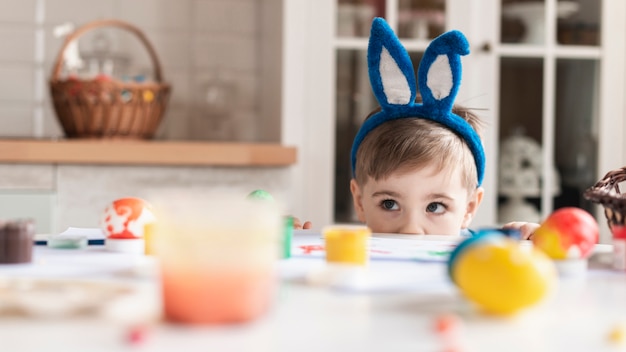 Adorable little boy with bunny ears hiding