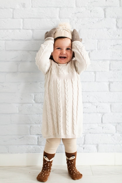 Free photo adorable little girl lifting her hat