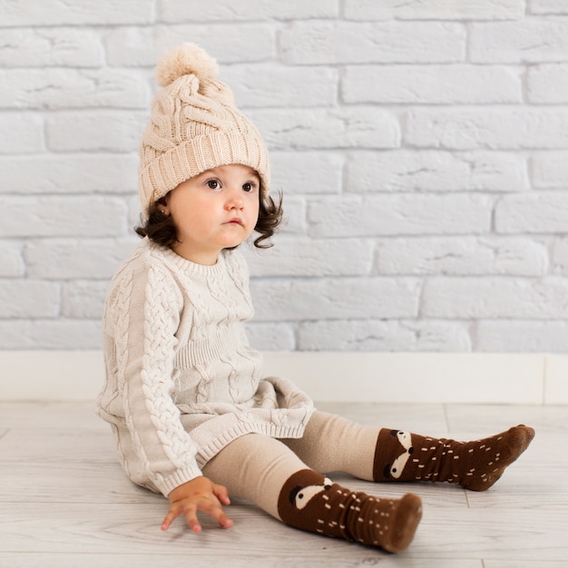 Free photo adorable little girl sitting on floor