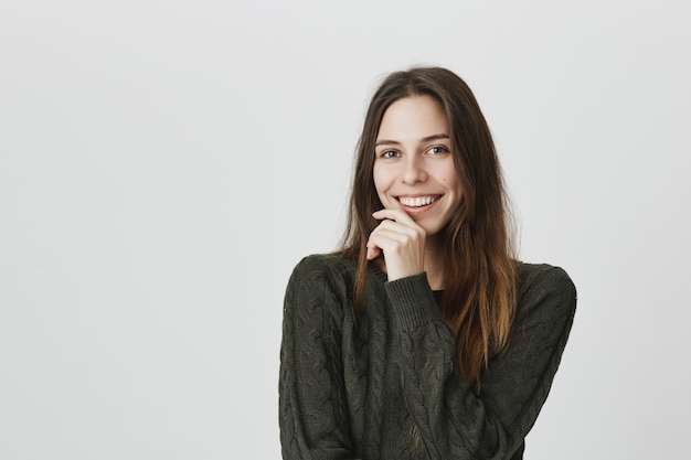 Adorable, romantic woman flirting and giggle at camera, smiling happy