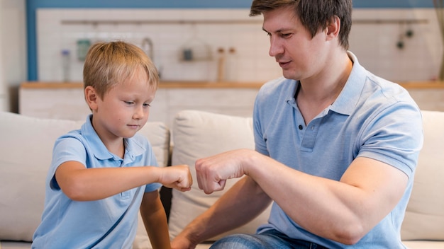 Adorable son playing with father at home