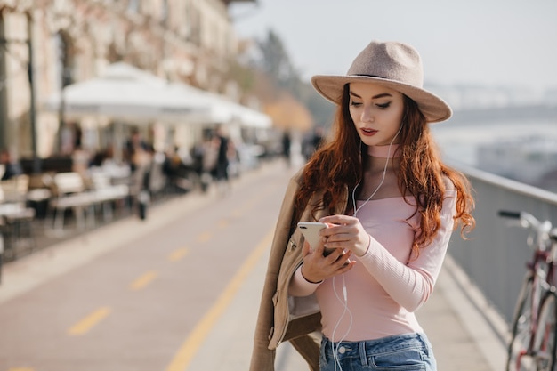 Adorable woman in pink shirt checking mobile mail