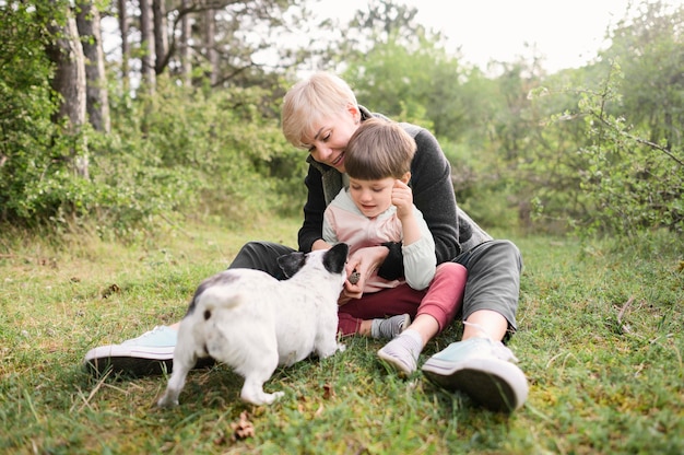 Adorable woman and young boy playing with dog