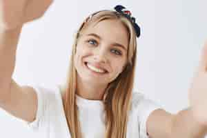 Free photo adorable young blond girl posing against the white wall